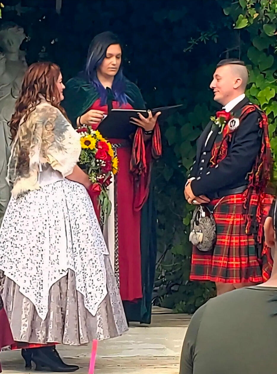 Couple wearing Scottish garb standing at the altar with the officiant