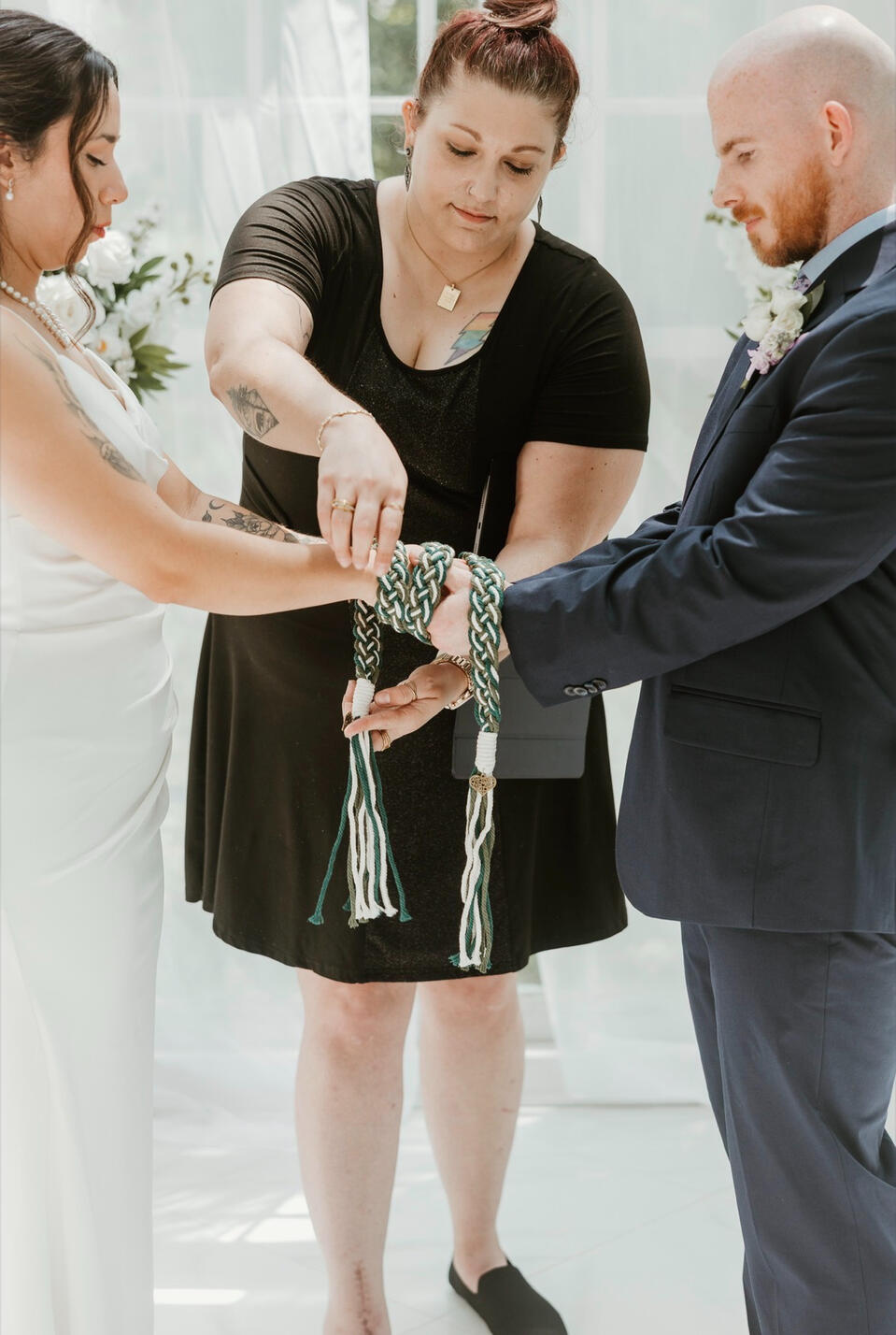 Officiate performing hand fasting ritual during a wedding ceremony