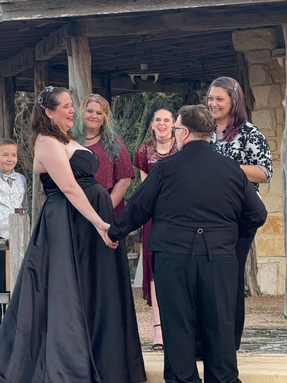 Couple standing at altar, holding hands, and laughing with the officiant
